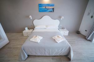 PollutriLa seconda Luna的卧室配有带毛巾的大型白色床