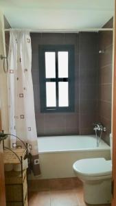 卡索拉VFT Sendero Cerezuelo的带浴缸、卫生间和窗户的浴室
