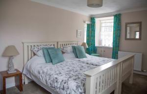 FenwickLangside Bed and Breakfast的一间卧室配有白色床和蓝色枕头