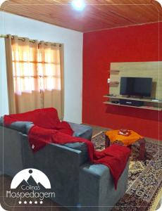 阿尤鲁奥卡Hospedagem Colinas的带沙发和电视的客厅