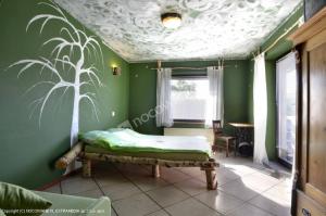 KostrzycaAgroturystyka Sielana的卧室设有一张位于绿色墙壁上的床铺