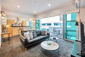 奥克兰Princes Wharf Boutique Apartments的客厅配有沙发和桌子