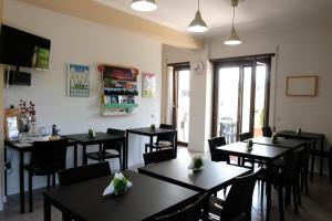 PreturoB&B Grandangolo的餐厅设有黑色桌椅和窗户。