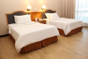米里梅加酒店的酒店客房,配有两张带白色床单的床