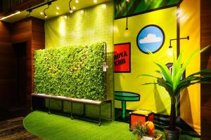高雄高雄富野渡假酒店的绿色的墙,长凳和植物