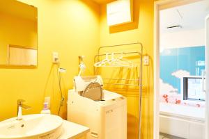 金泽Hyotan TABI-NE的黄色的浴室设有水槽和卫生间