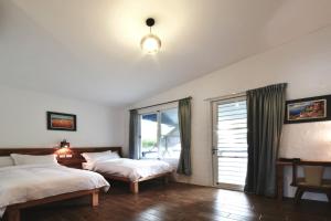 Hai-liao榄人生态民宿 的一间卧室设有两张床和窗户。