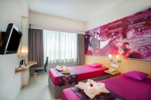 梭罗favehotel Manahan - Solo的一间酒店客房,设有两张床和电视