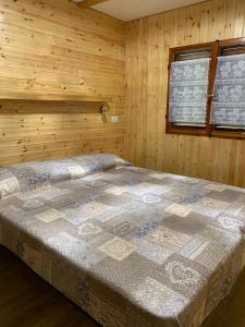 安泰伊-萨伊恩特-安德尔埃维拉吉奥塞维诺旅游营地的木制客房内的一间卧室,配有一张床