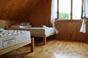 NaujeneBeibuki的客房内设有两张床,铺有木地板,设有窗户。