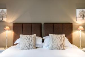 肯德尔卡鲁斯绿色高尔夫俱乐部度假屋的一间卧室配有带白色床单和枕头的床。