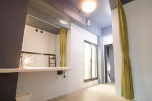 宜兰市飞包客青年旅店的客房设有带水槽和窗户的厨房