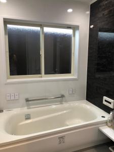 下关Guest House "Ro"kumano的带窗户的浴室内的白色浴缸