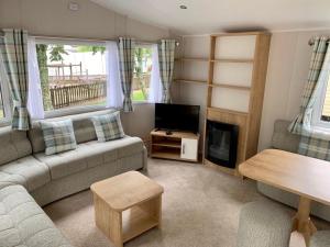 卡纳芬Brynteg Coastal & Country Retreat的带沙发和电视的客厅