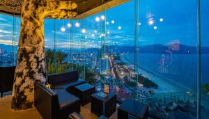 岘港Sala Danang Beach Hotel的客房设有大窗户,享有城市美景。