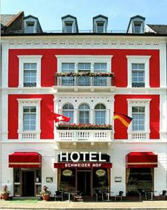 巴登-巴登施韦策霍夫高级酒店的一座红白色的建筑,与酒店同在