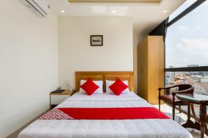 头顿Marine Hotel & Apartment的一间卧室配有一张带红色枕头的床和一扇窗户