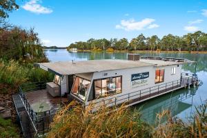 伦马克Renmark River Villas and Boats & Bedzzz的湖上码头上的一个小房子