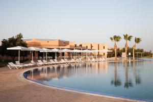 马拉喀什Marrakech Ryads Parc All inclusive的度假村内带椅子和遮阳伞的游泳池