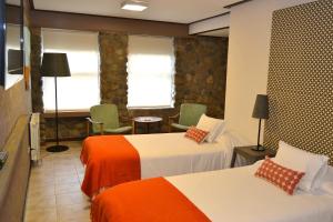 埃尔卡拉法特埃尔卡拉法特ACA酒店的酒店客房带两张床,带橙色和白色的床单。