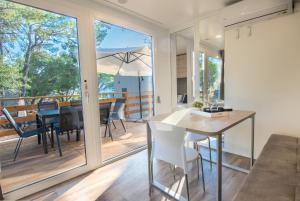 马卡尔斯卡Apartments and Mobile Homes Makarska的厨房以及带桌椅的用餐室。