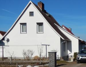 于克里茨Ferienwohnung Seestern Ückeritz的前面有一辆汽车停放的白色房子