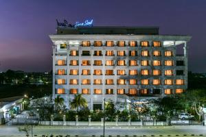 舍地西瑞狄阳光沙滩酒店的一座酒店大楼,上面有 ⁇ 虹灯标志