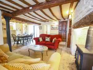 伯福德Murton Cottage的客厅配有红色的沙发和桌子