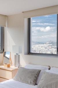 雅典GB Athens View Luxury Suite的一间卧室设有两张床和大窗户