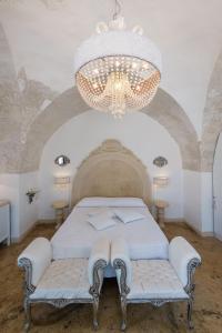 加利波利Palazzo Gallo Resort的一间卧室配有一张床和一个吊灯