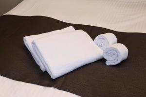广岛HOTEL PROMOTE HIROSHIMA的一张带两条毛巾和两卷毛巾的床