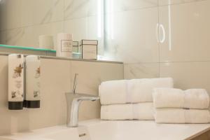 雷特温克尔奥贝斯赫米德酒店的浴室提供白色毛巾、水槽和镜子