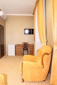 日托米尔Оздоровчий комплекс Гайки заїзд провулок Сухий Яр 12的客厅配有黄色椅子和书桌