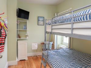 波马利斯Gadlys House - Beau View的一间卧室配有双层床和平面电视