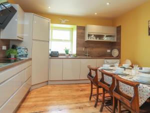 波马利斯Gadlys House - Beau View的厨房配有桌椅和冰箱。