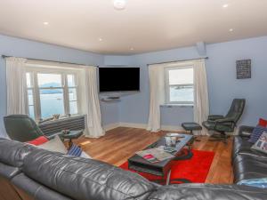 波马利斯Gadlys House - Beau View的客厅配有真皮沙发和平面电视