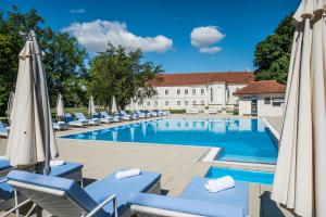 Tomášov艺术庄园酒店的酒店游泳池设有椅子和遮阳伞