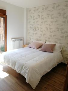 卡马雷纳德拉谢拉Apartamentos La Réunion的卧室配有带粉红色枕头的大型白色床