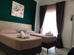 阿格里真托B&B Le Stanze Al Centro的配有两张床的客房,设有绿色的墙壁和窗户