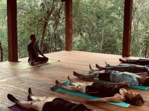 迪加纳普瓦莎生态小屋酒店的一群坐在地板上参加瑜伽课的人