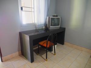湄南海滩苏梅岛可可别墅酒店的一张桌子、一台电视和一把椅子