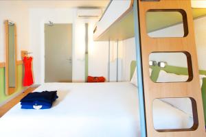 普瓦捷普瓦捷车站宜必思快捷酒店的卧室配有白色的床和2扇窗户。