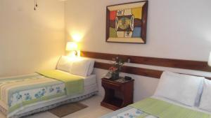 太子港棕榈酒店的酒店客房设有两张床,墙上挂着一张照片。