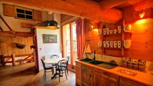 勒布罗伊斯Cosy Lodge au pied de l'Alpe D'Huez SKi et Détente Jacuzzi Piscine Sauna Bar Billard的小屋内的厨房配有桌子和水槽