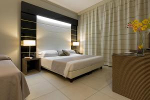那不勒斯萨尔加宫酒店的一间卧室,配有一张床和花瓶