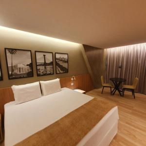 特雷西纳蓝树塔里约波蒂酒店的卧室配有一张白色的大床和一张桌子