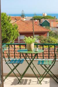 埃斯托利尔Your Place in Estoril的种植了植物的阳台的桌椅