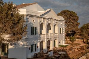 阿莱奥尔Menorca Experimental的前面设有桌椅的白色房子