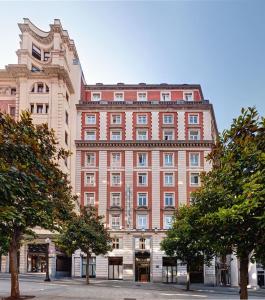 希洪埃尔南科尔特斯酒店的一座大型红砖建筑,前面有树木