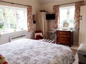WhichfordWayside House B&B的一间卧室设有一张大床和两个窗户。